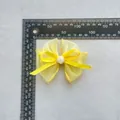 Vista macro de lazo de organza amarilla con rosa y escala de medición de 9,5 cm - Amarillo