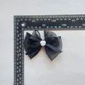 Makroaufnahme von 10,5cm schwarzer Chiffonschleife mit weißer Harzrose und Linealmaß - Schwarz
