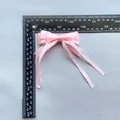 Vue détaillée d'un nœud en satin rose avec rubans, largeur 90 mm mesurée à la règle - Style Simple Rose (6)