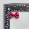 Detalle macro de un lazo de tela roja con textura, tamaño 35mm-40mm junto a una regla - Tela Texturizada Rosa Oscuro (6)