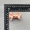 Detailed view of 6cm peach pink satin and mesh layered bow with ruler for size reference - Coral Pink