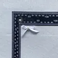 Detailed view of handmade white ribbon bow with pearl center on metric measuring tool - White (8)