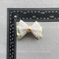 Detail der cremefarbenen Tüllschleife mit Glitzerakzenten und Maßstabslineal - Cremefarbenes Satinband mit buntem Glitzergitter-Stil(6)