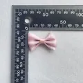 Detalle de lazo de satén rosa con patrón de purpurina plateada sobre tela gris - Satén Rosa Con Estrellas (17)