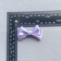 Dettaglio di un fiocco in raso viola da 45mm con cuore bianco e scala di misurazione - Lavanda
