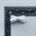 Detailopname van witte DIY kanten strik met hartkraal en schaalmeting van de grootte - Kant Hart Iriserende Stijl(9)