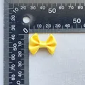 Macro detail of a small yellow satin bow accessory with scale ruler measurement - Yellow (7)