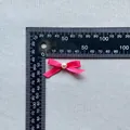 Macro detail of a 35mm pink ribbon bow with a center pearl for DIY cake decoration - Pink (11)