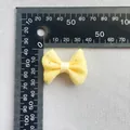Vista detallada del pequeño lazo de organza amarilla con medida de 45 mm en regla - Malla Amarilla Con Puntos (5)