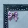 Detailansicht einer 4cm lila Ripsbandschleife mit Strassstein und Maßstab auf Stoff - Lila (Kristallstein)