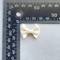 Dettaglio di un fiocco in raso avorio da 3cm misurato con righello per progetti fai-da-te - Bianco avorio (14)