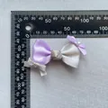 Detail einer handgefertigten zweifarbigen Schleife mit Strasssteinen auf einer Messskala - Lila Weiß Mix (11)