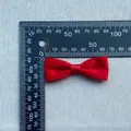 Detailed view of a red handmade satin bow showing size measurement with a ruler - Glossy Red Satin Style
