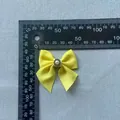 Detail view of yellow grosgrain bow accessory with pearl center and sizing ruler - Yellow (Pearl)