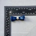 Detalle de un lazo de satén azul marino de 40 mm con perla para decoración DIY - Azul marino