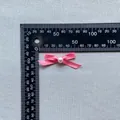 Detailed close-up of a pink satin bow with a white pearl bead decoration and size scale - Pink Purple (18)
