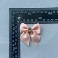 Detail of pink grosgrain ribbon bow with a crystal rhinestone center measuring 50mm - Light Pink (Rhinestone)