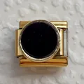 Vista macro di un charm italiano modulare dorato con un inserto centrale in smalto nero - Base Oro Nero