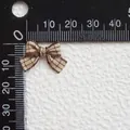 Vista detallada de un mini lazo a cuadros marrón con regla de medición para accesorios DIY - Cuadros Café Y Beige