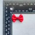 Dettaglio macro della dimensione e trama di un fiocco in raso rosso da 3cm per il fai-da-te - Cremisi (11)