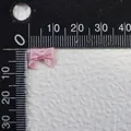 Dettaglio di un piccolo fiocco di raso rosa da 10mm con scala graduata per misura - Stile Rosa