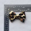 Detalle de un lazo de raso de 80 mm con estampado de leopardo y regla de medida - Lazo de una Sola Capa / Estilo Leopardo Puro