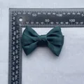 Detail of dark green satin bow accessory showing size measurement with a ruler - Dark Green