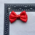 Detailed top view of red satin double bow with measurement ruler showing 80mm width - Red
