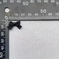 Vista macro di un piccolo fiocco di raso nero di 2 cm su una scala graduata - Nero (11)