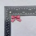 Detailed view of red gingham fabric bow with a ruler showing the 25mm size specifications - Red White Gingham Ribbon With Tails