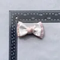 Detail view of pink and white satin bow showing 10cm width measurement with a ruler - Light Pink and White (6)