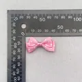 Detail view of a 40mm pink polka dot ribbon bow with measurement ruler for scale - Pink White Polka Dot (13)