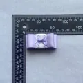 Detailopname van een paarse gelaagde kanten strik met een liniaal voor DIY-handwerkmaten - Paars