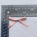 Makroansicht einer hellrosa Satinschleife von 45 mm Breite mit einem Lineal - Blassrosa (12)