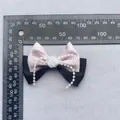 Detalle macro del lazo de seda con perlas y rosa blanca sobre fondo de tela gris - Rosa carne