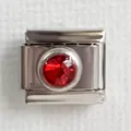 Macro view of Italian charm link featuring a faceted red birthstone in silver steel - Red