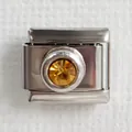 Macro shot of stainless steel Italian charm link with an amber gemstone for DIY bracelets - Amber