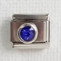 Macro shot of stainless steel Italian charm with round faceted deep blue gemstone inlay - Dark Blue