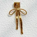 Vista macro de un amuleto de lazo dorado en un eslabón de pulsera modular italiana pulida - Lazo