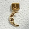 Macro de un charm italiano de acero dorado con colgante vintage de cara de luna esculpida - Luna Delgada