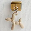 Dettaglio di un ciondolo a forma di cane palloncino crema su una maglia d'oro italiana - Marrone Beige