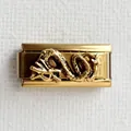 Vue macro d'un maillon de bracelet italien en acier doré avec un motif de dragon en relief - Base Or Dragon Doré