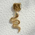 Detalle de dije de serpiente dorada con ojo de gema verde en pulsera modular italiana - Serpiente