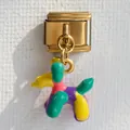 Dettaglio ravvicinato di un ciondolo a forma di cane palloncino colorato in smalto dorato - Colorato