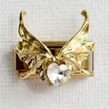 Macro detail of Italian charm bracelet link with gold butterfly wings and heart crystal - Heart Wings Gold Style