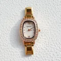 Detail van gouden quartzhorloge met kristallen ovale wijzerplaat en metalen schakelband - Ingelegde Witte Wijzerplaat