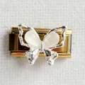 Macro shot of silver butterfly charm link with white stones on golden metal base - Butterfly Gold Style 1