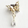 Macro shot of stainless steel charm with golden butterfly and clear crystal teardrop - Butterfly