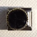 Macro shot of Italian charm bracelet link with black inlay and golden gear edge detail - Black