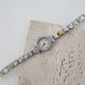 Dettaglio di un orologio a bracciale con ciondoli in smalto colorato e quadrante con strass - Quadrante Bianco Argento Strass Multicolore